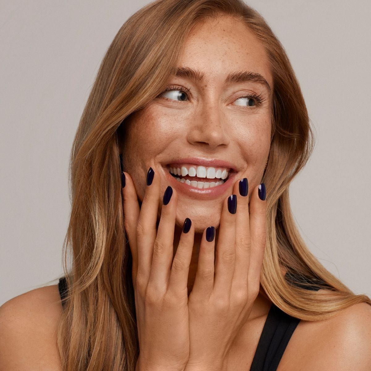 Smiling customer with a dark manicure